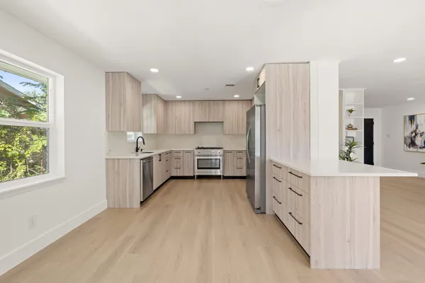 a kitchen with stainless steel appliances a sink and a refrigerator