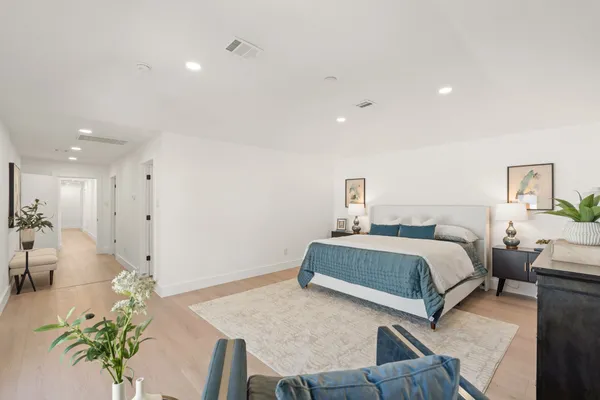 a bedroom with a bed and a potted plant