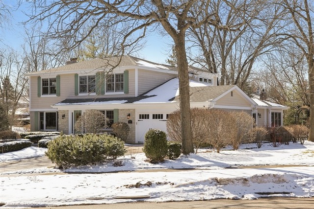 a front view of a house with a yard covered in snow