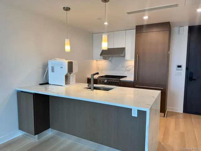 a kitchen with kitchen island a sink stainless steel appliances and cabinets