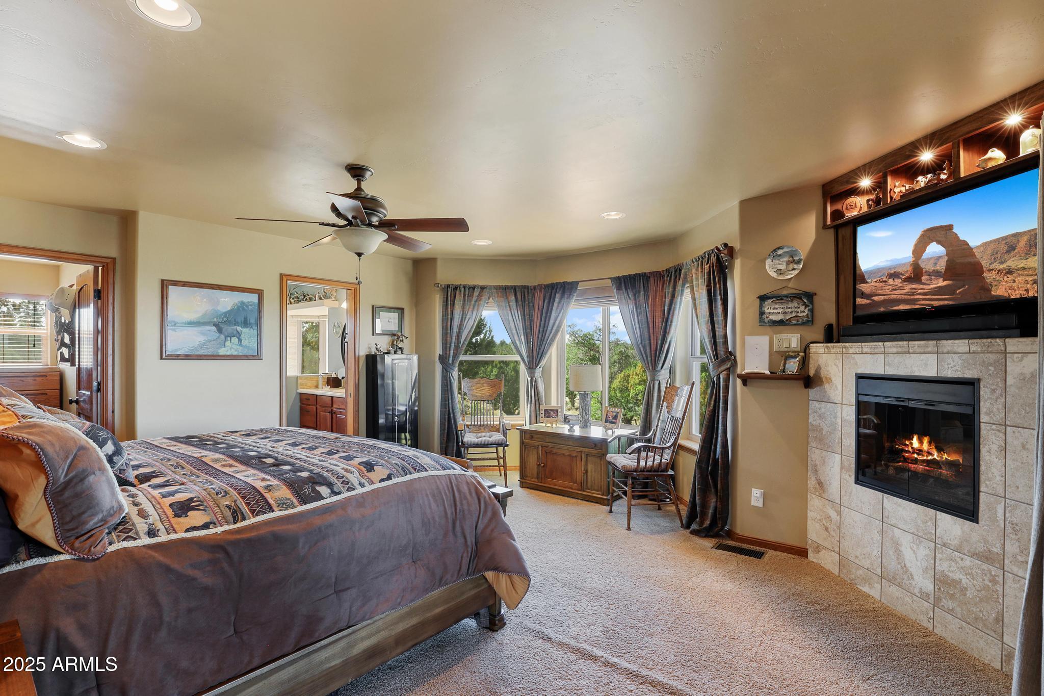 4018 Sunset Rdg Loop Happy Jack, AZ 86024 - Photo 16 of 46 a bedroom with a bed a flat screen tv and a fireplace