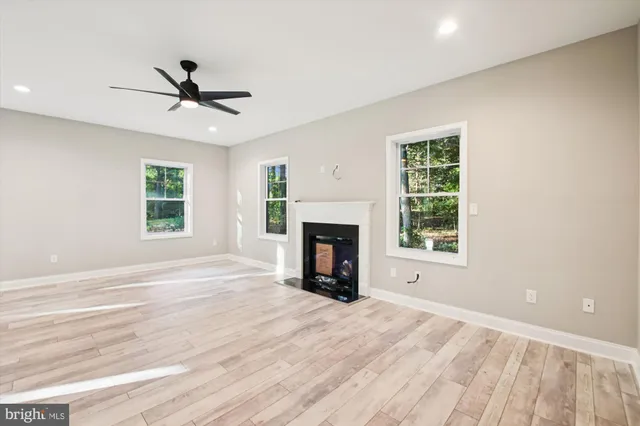 a view of an empty room with window and fire place