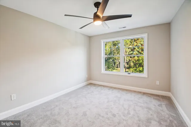 an empty room with a window and a fan