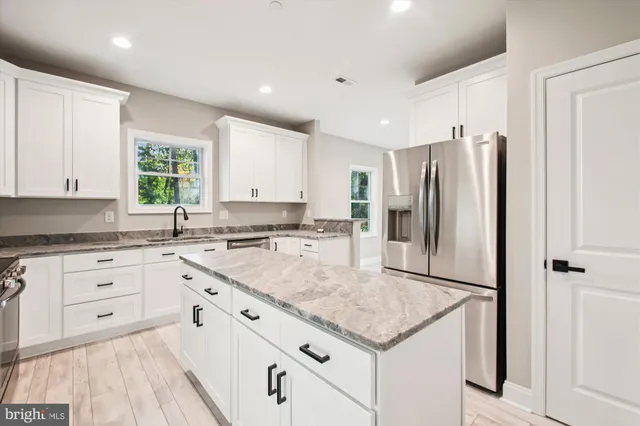 a kitchen with granite countertop a sink appliances cabinets and counter space