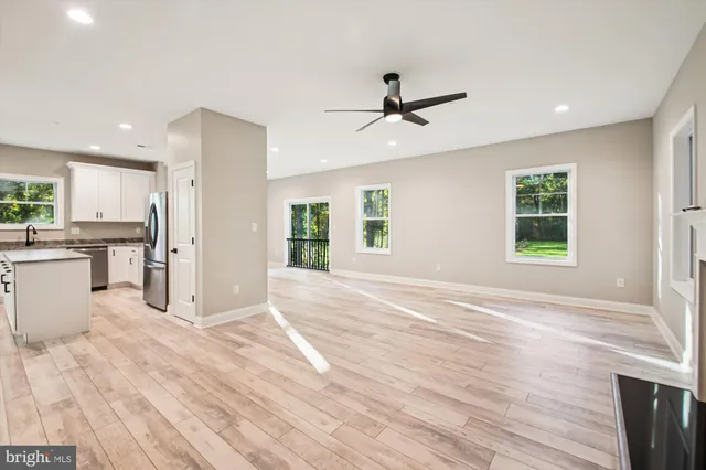 a view of livingroom with hardwood floor and a kitchen