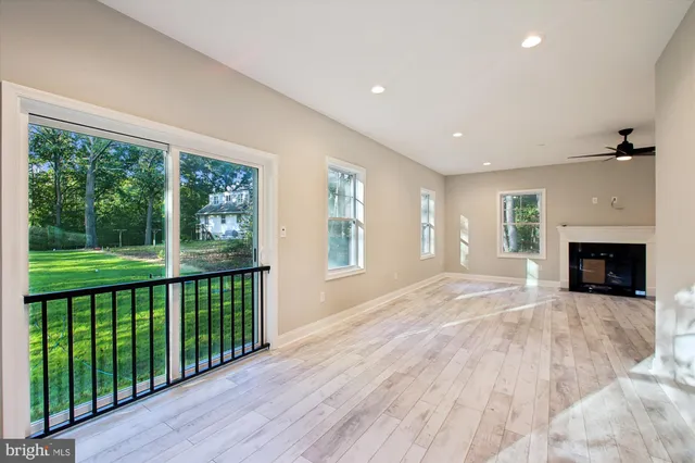 a view of empty room with wooden floor and fireplace