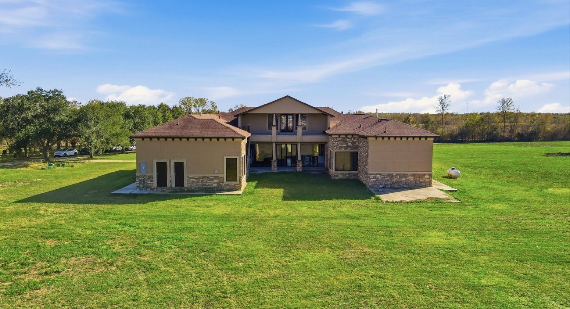 7348 Love Road Fulshear, TX 77441 - Photo 48 of 48 Two-story home with a blend of modern and rustic charm, set on a vast green landscape offering serene privacy.