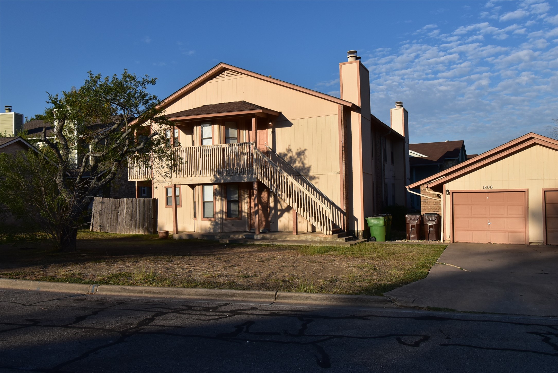 1806 Rawhide Loop Round Rock, TX 78681 - Photo 21 of 23 View of front facade featuring chimney, concrete driveway, front yard, front balcony, and outdoor structure