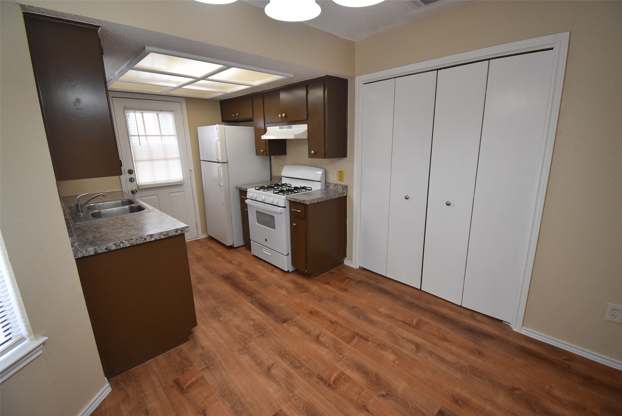 1806 Rawhide Loop Round Rock, TX 78681 - Photo 10 of 23 Kitchen with white appliances, dark wood finish cabinets, laminate flooring, and light countertops