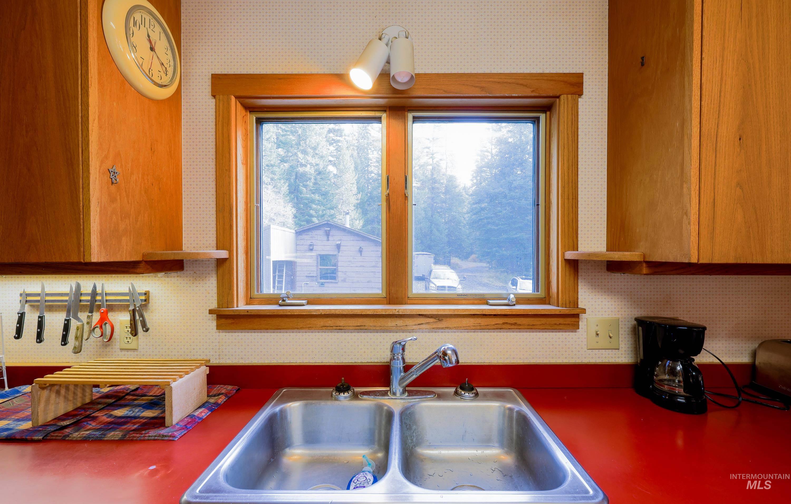 1021 Claypit Road Troy, ID 83871 - Photo 21 of 44 Kitchen featuring wallpapered walls and brown cabinetry