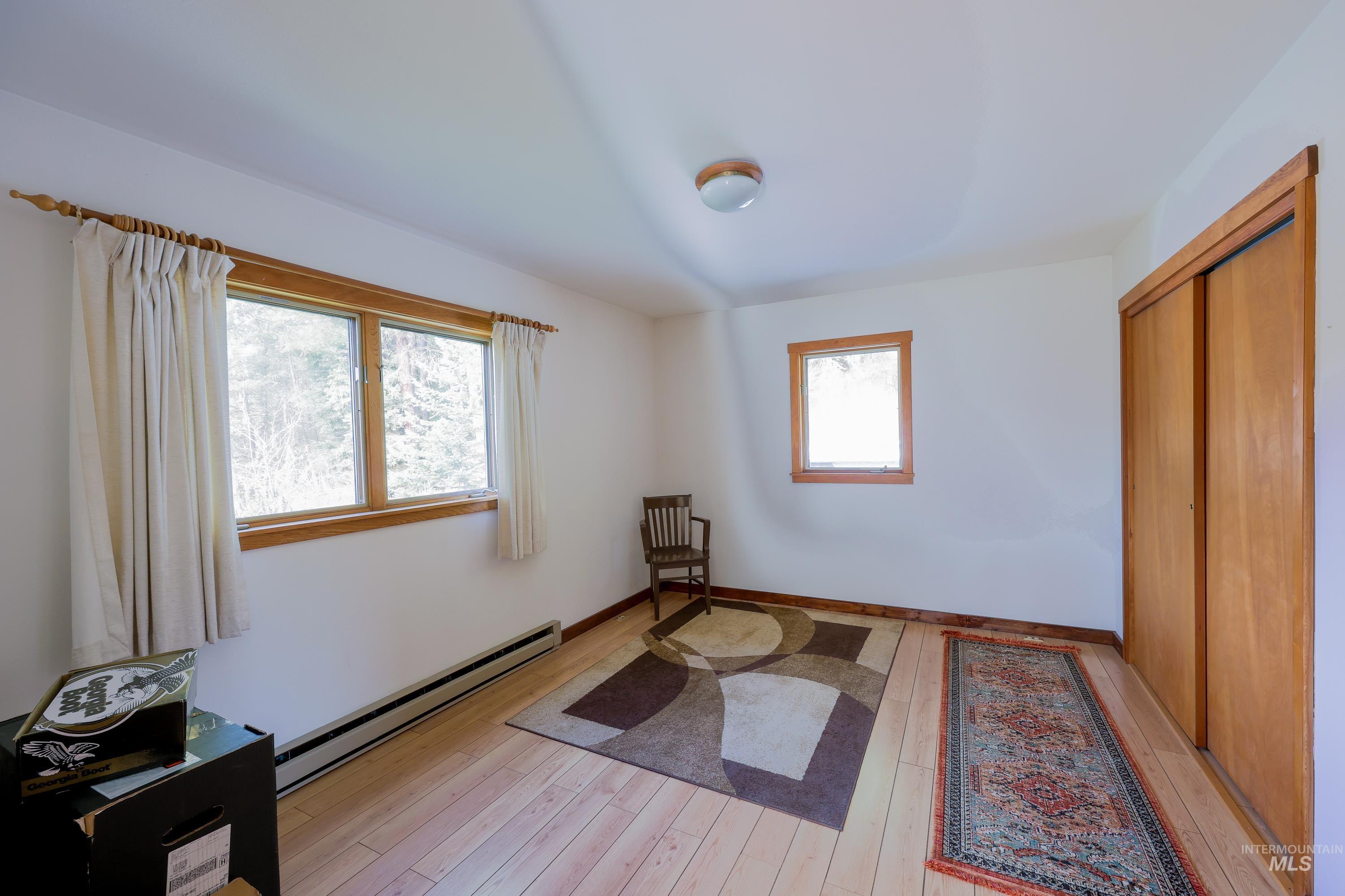 1021 Claypit Road Troy, ID 83871 - Photo 27 of 44 Bedroom featuring a baseboard heating unit, light wood-style floors, and a closet