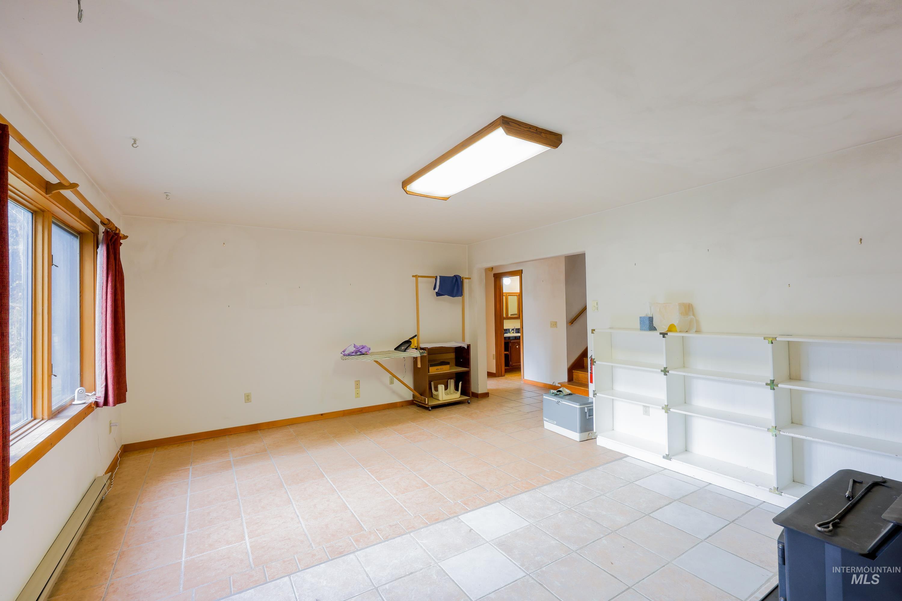 1021 Claypit Road Troy, ID 83871 - Photo 31 of 44 Empty room featuring a baseboard heating unit and light tile patterned flooring