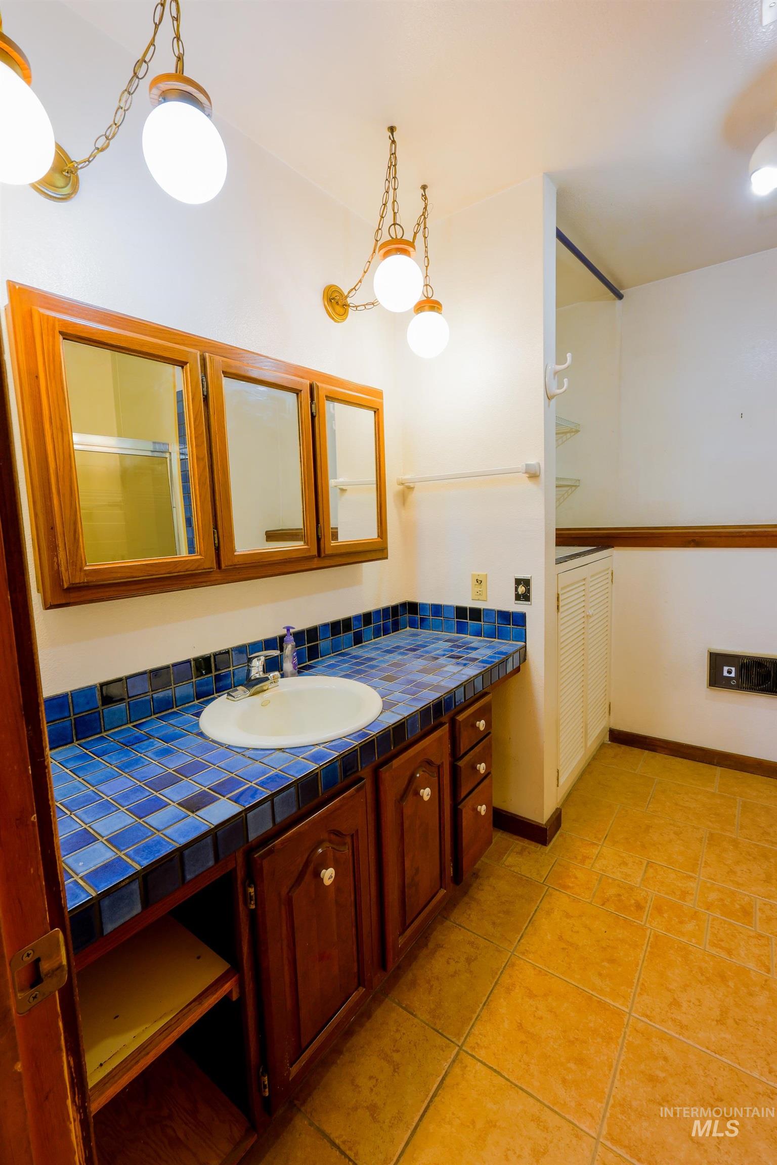 1021 Claypit Road Troy, ID 83871 - Photo 33 of 44 Bathroom with vanity, light tile patterned flooring, and a shower with shower door