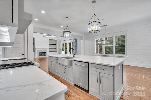 a kitchen with granite countertop a stove and a wooden floor