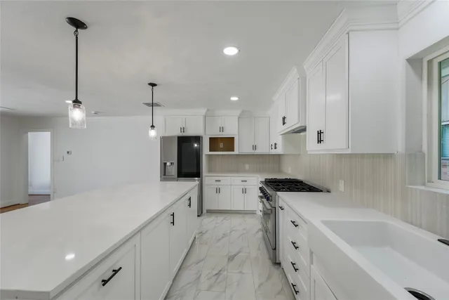 a kitchen with a sink a counter top space stainless steel appliances and cabinets