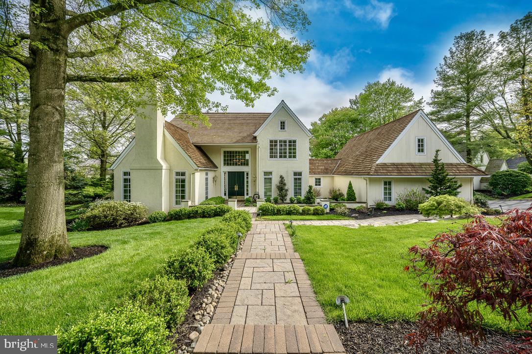 a front view of a house with a yard and potted plants
