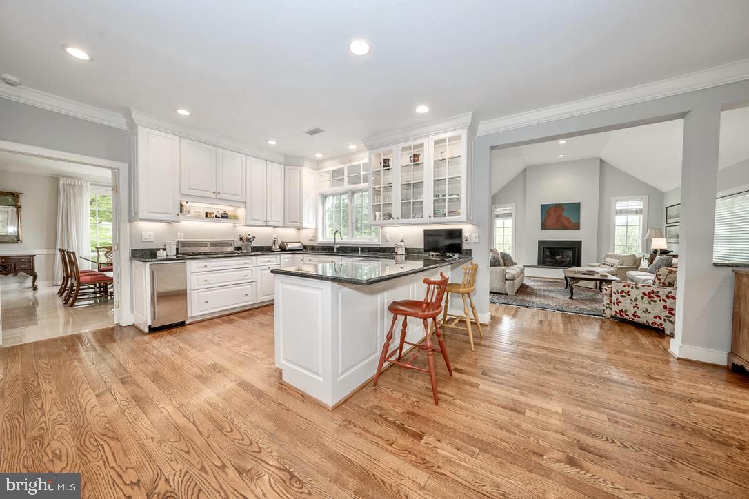 1201 Denbigh Lane Wayne, PA 19087 - Photo 10 of 54 a kitchen with stainless steel appliances a stove a sink a refrigerator white cabinets and couches with wooden floor