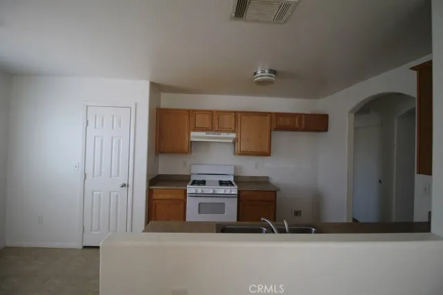 a kitchen with stainless steel appliances granite countertop a refrigerator and a stove