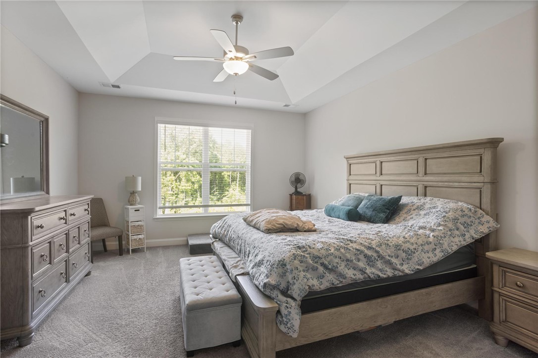 125 Estateside Drive Anderson, SC 29621 - Photo 16 of 37 A well-lit primary bedroom features a classic bed frame and abundant natural light from a broad window.