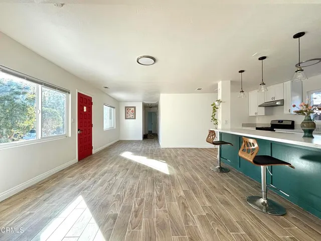 a view of kitchen and hall with wooden floor