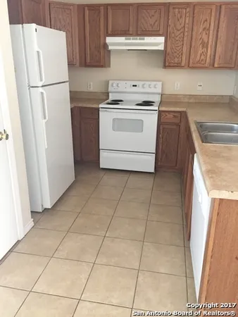 a kitchen with a stove top oven and refrigerator