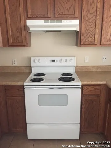 a stove top oven sitting inside of a kitchen