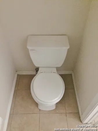 a bathroom with a toilet and a rug