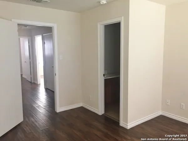 a view of a hallway with wooden floor