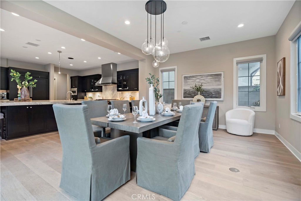115 Interstellar Irvine, CA 92618 - Photo 13 of 36 a view of a dining room with furniture a chandelier and wooden floor