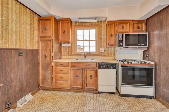 a kitchen with stainless steel appliances a stove a sink and a microwave