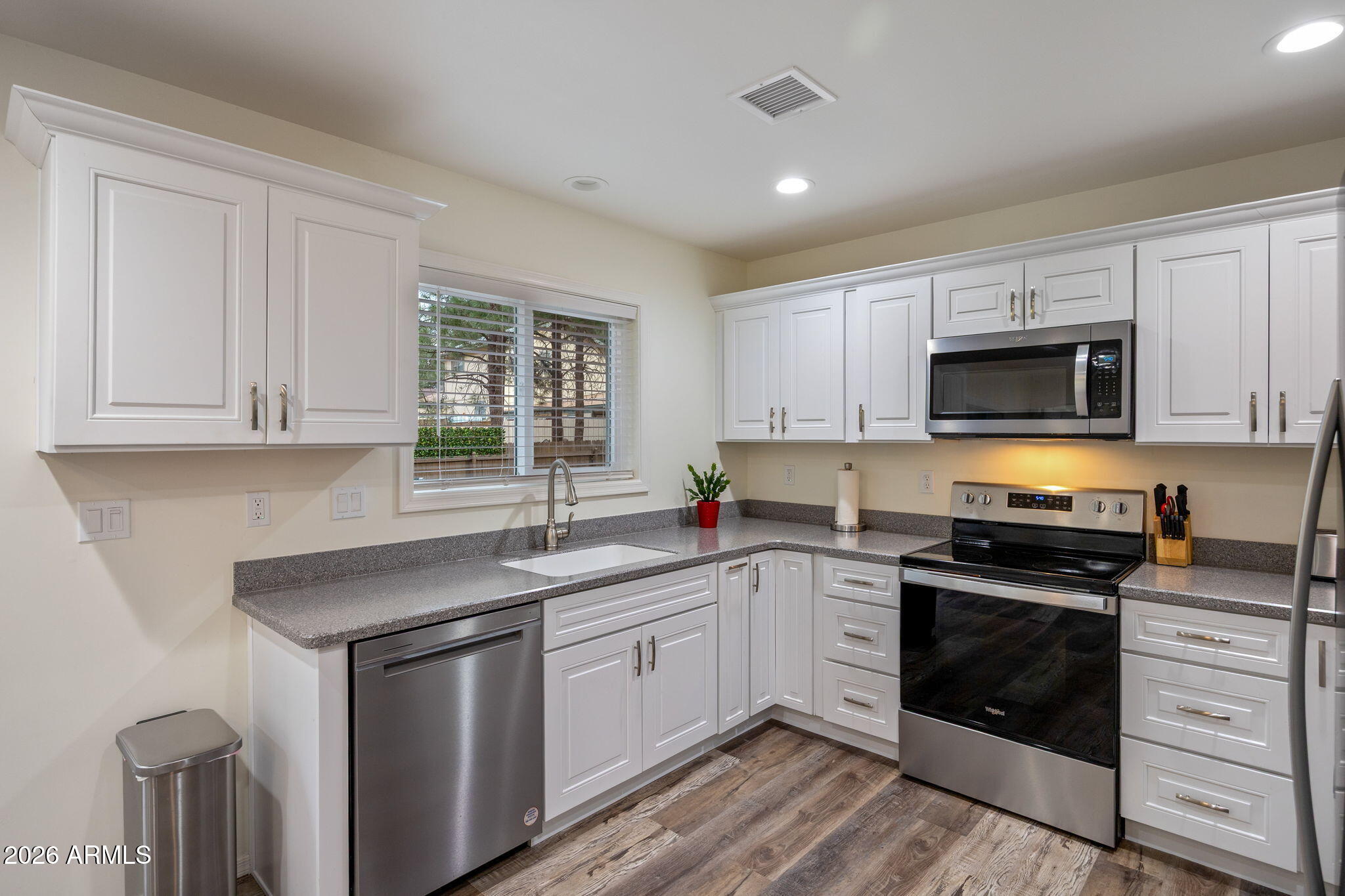 5145 Drifting Snow Loop Pinetop, AZ 85935 - Photo 11 of 37 a kitchen with stainless steel appliances granite countertop white cabinets a sink a stove a microwave and wooden floors