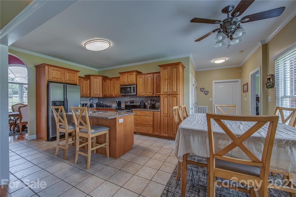 936 Ferguson Ridge Road Gastonia, NC 28052 - Photo 9 of 30 a kitchen with a dining table chairs stainless steel appliances and cabinets