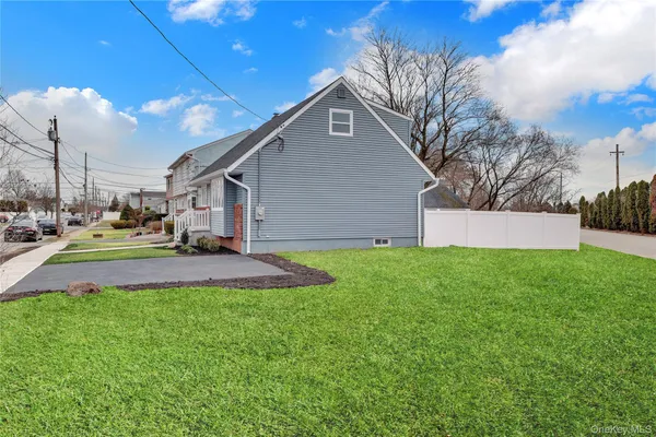 a front view of a house with a yard and trees