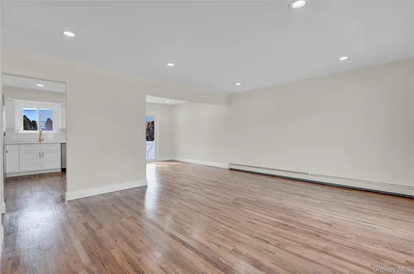 a view of empty room with wooden floor and windows