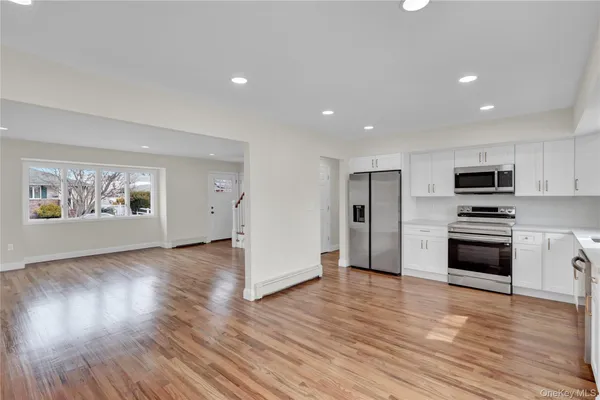 a view of kitchen with microwave and wooden floor