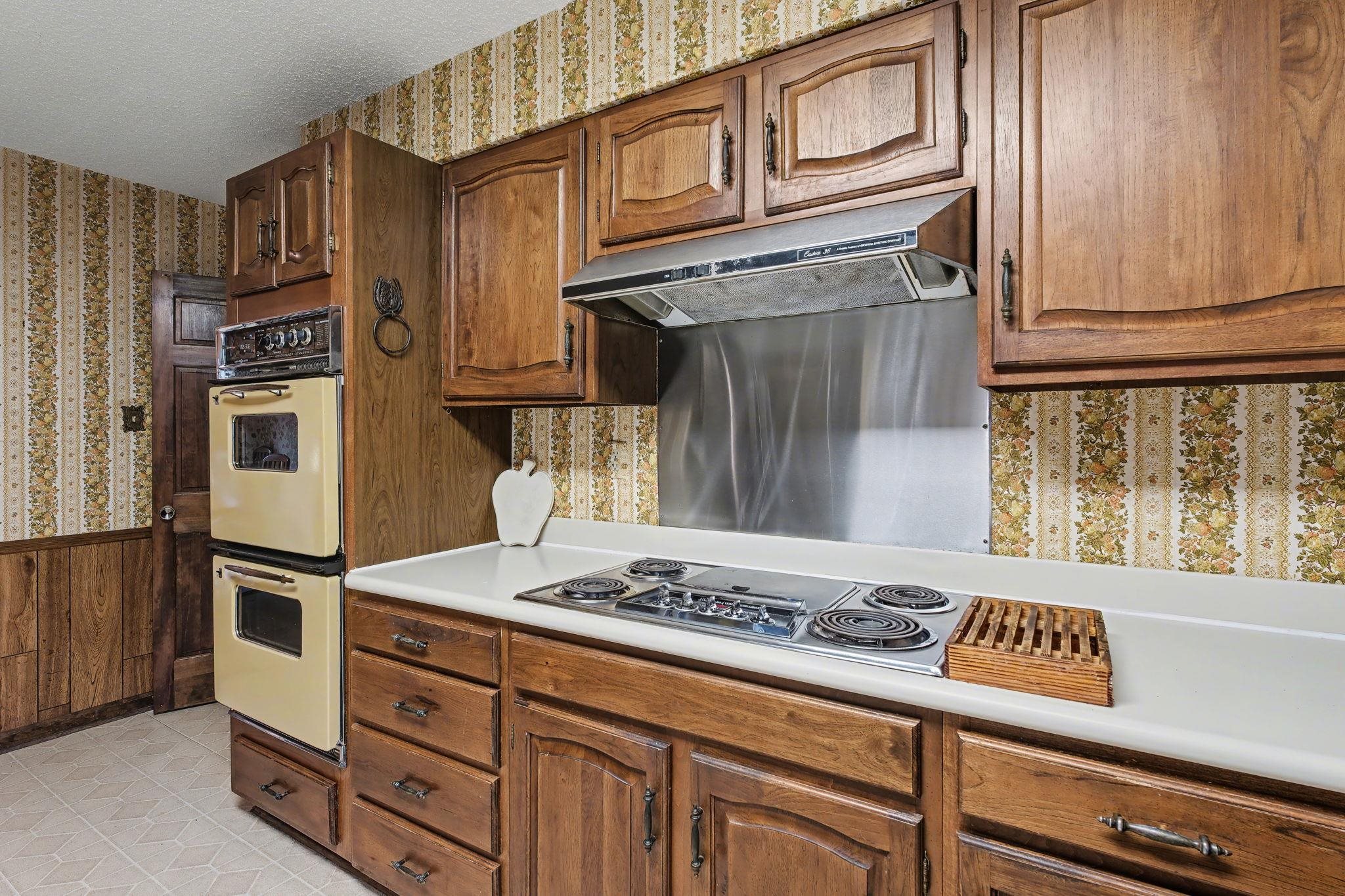 11380 Sycamore Farms Road Collierville, TN 38017 - Photo 16 of 35 Kitchen with wallpapered walls, light countertops, a wainscoted wall, stainless steel electric cooktop, and a textured ceiling