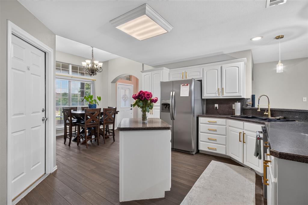 100 Radecke Road Krum, TX 76249 - Photo 13 of 29 Kitchen featuring white cabinetry with gold-toned hardware, dark countertops, and wood-finish flooring