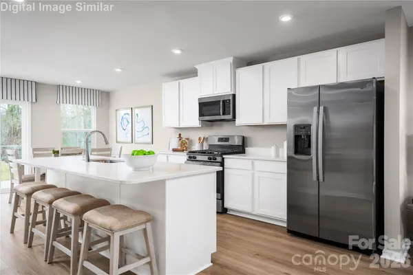a kitchen with stainless steel appliances a refrigerator sink and microwave