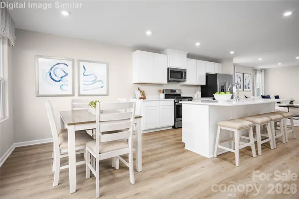 a kitchen with stainless steel appliances kitchen island granite countertop a dining table chairs and view living room