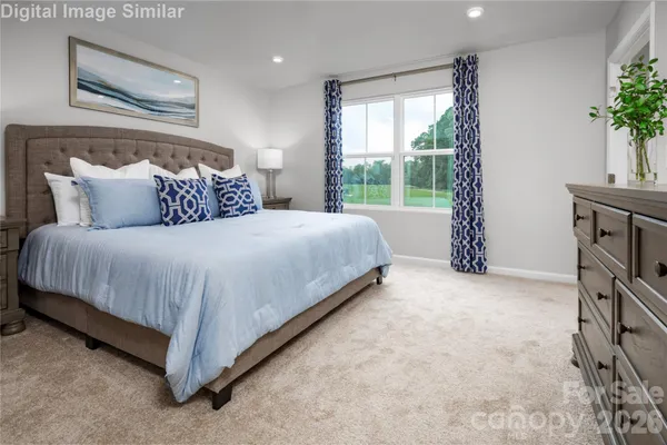 a large bed sitting in a bedroom next to a window