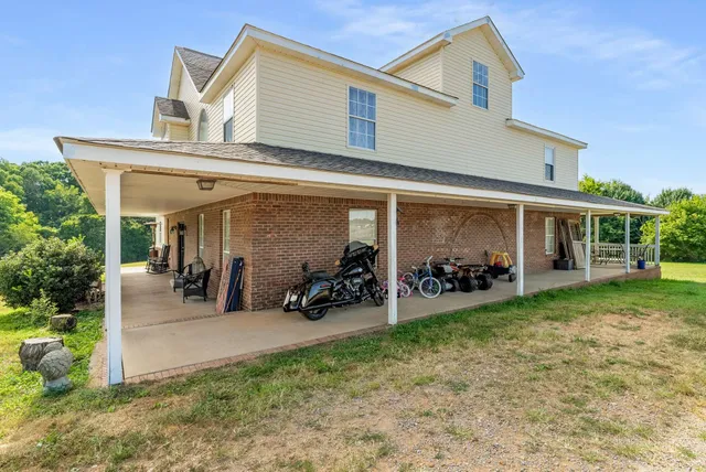 a view of a house with a patio and a yard