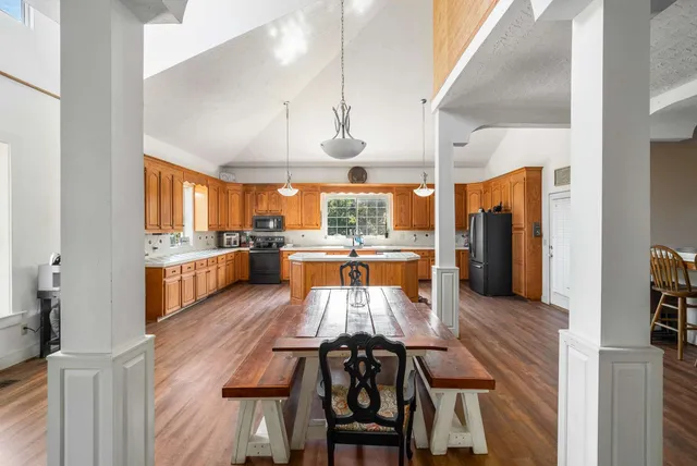 a kitchen with a sink stove and wooden floor