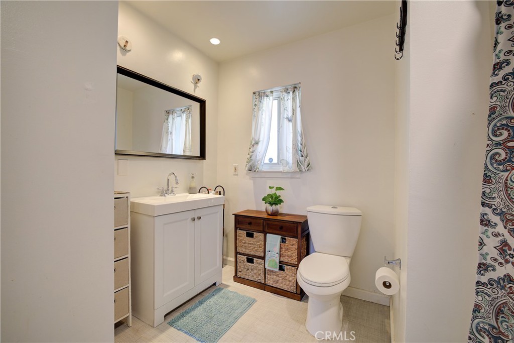 1140 North Belden Avenue Rialto, CA 92376 - Photo 16 of 37 a bathroom with a toilet a sink and mirror