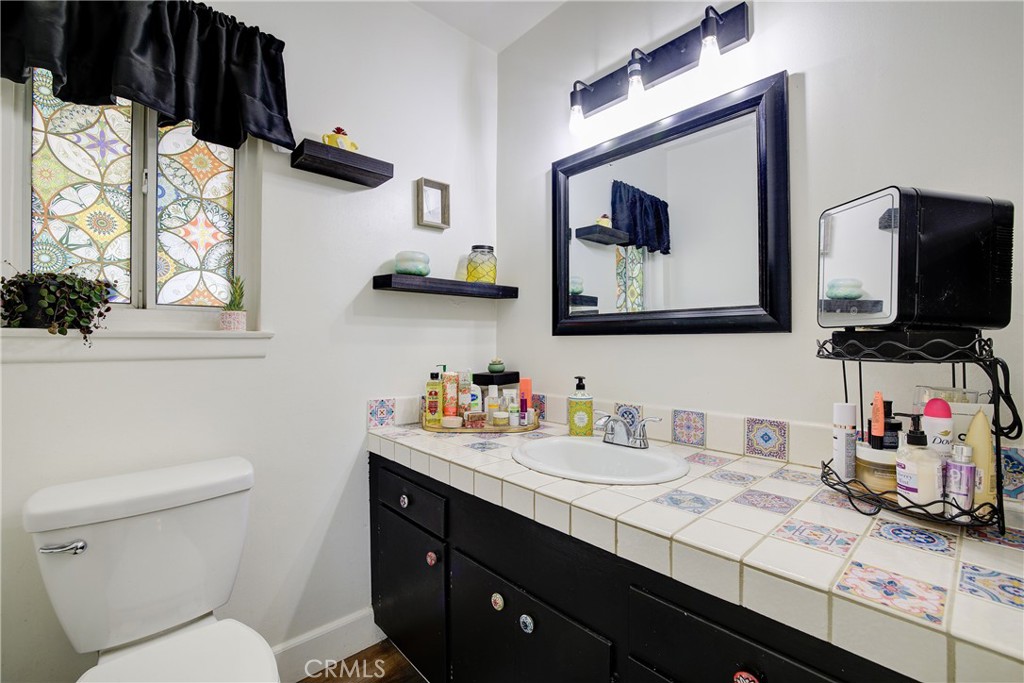 1140 North Belden Avenue Rialto, CA 92376 - Photo 21 of 37 a bathroom with a toilet sink and mirror