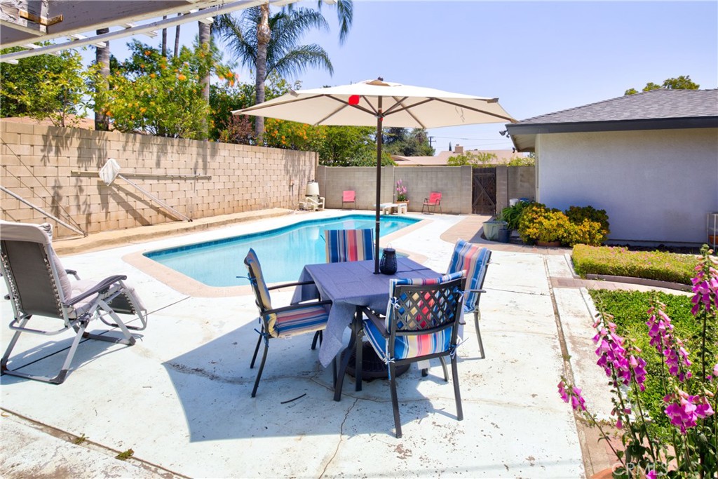 1140 North Belden Avenue Rialto, CA 92376 - Photo 23 of 37 a view of a dining table and chairs under an umbrella in patio