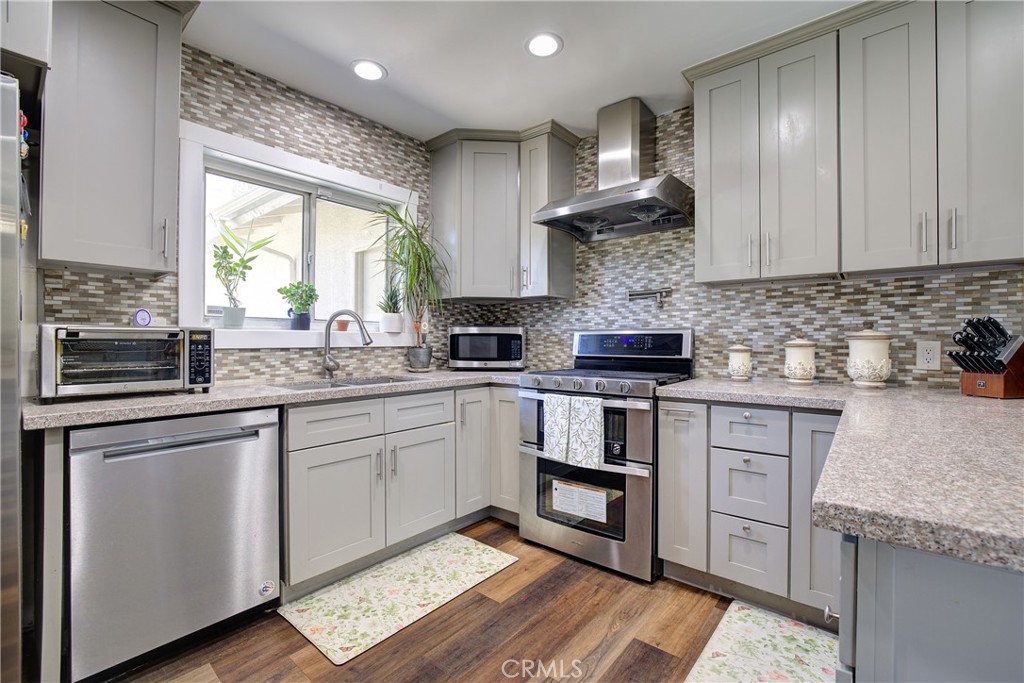 1140 North Belden Avenue Rialto, CA 92376 - Photo 9 of 37 a kitchen with stainless steel appliances granite countertop a stove a sink and a microwave