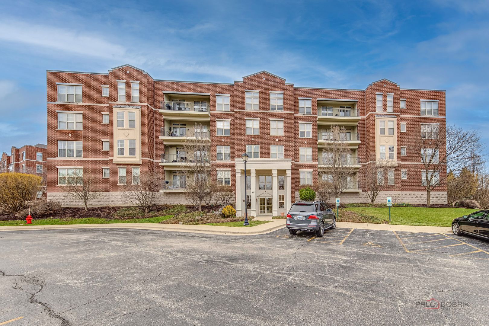 720 Prestwick Lane, Unit 302 Wheeling, IL 60090 - Photo 1 of 23 a front view of a residential apartment building with a yard
