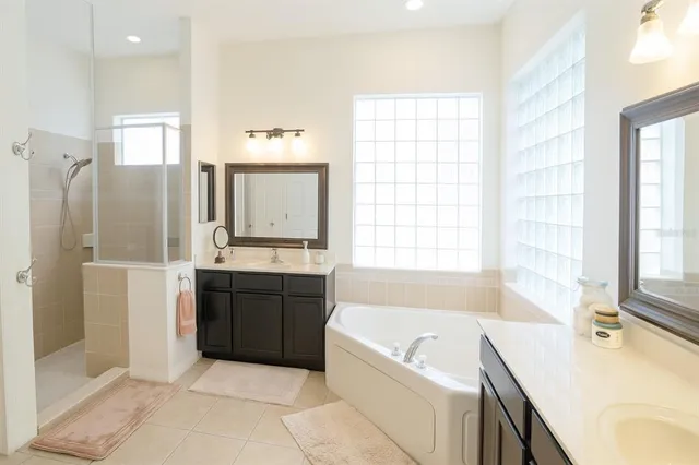 a spacious bathroom with a tub sink and mirror