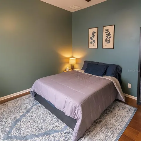 a bedroom with a bed and a flat tv screen on dresser