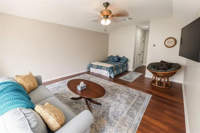 a bedroom with a bed a couch and windows